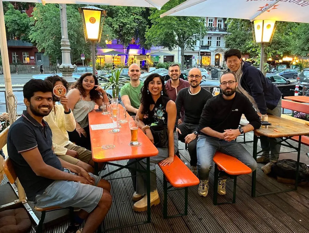 Group of about 10 people sitting at outdoor tables on a summer evening at Brauhaus Südstern