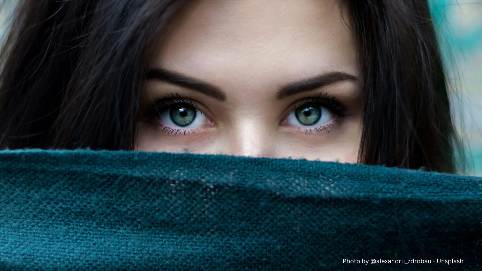 A woman, hidden behind the scarf, looking at the camera